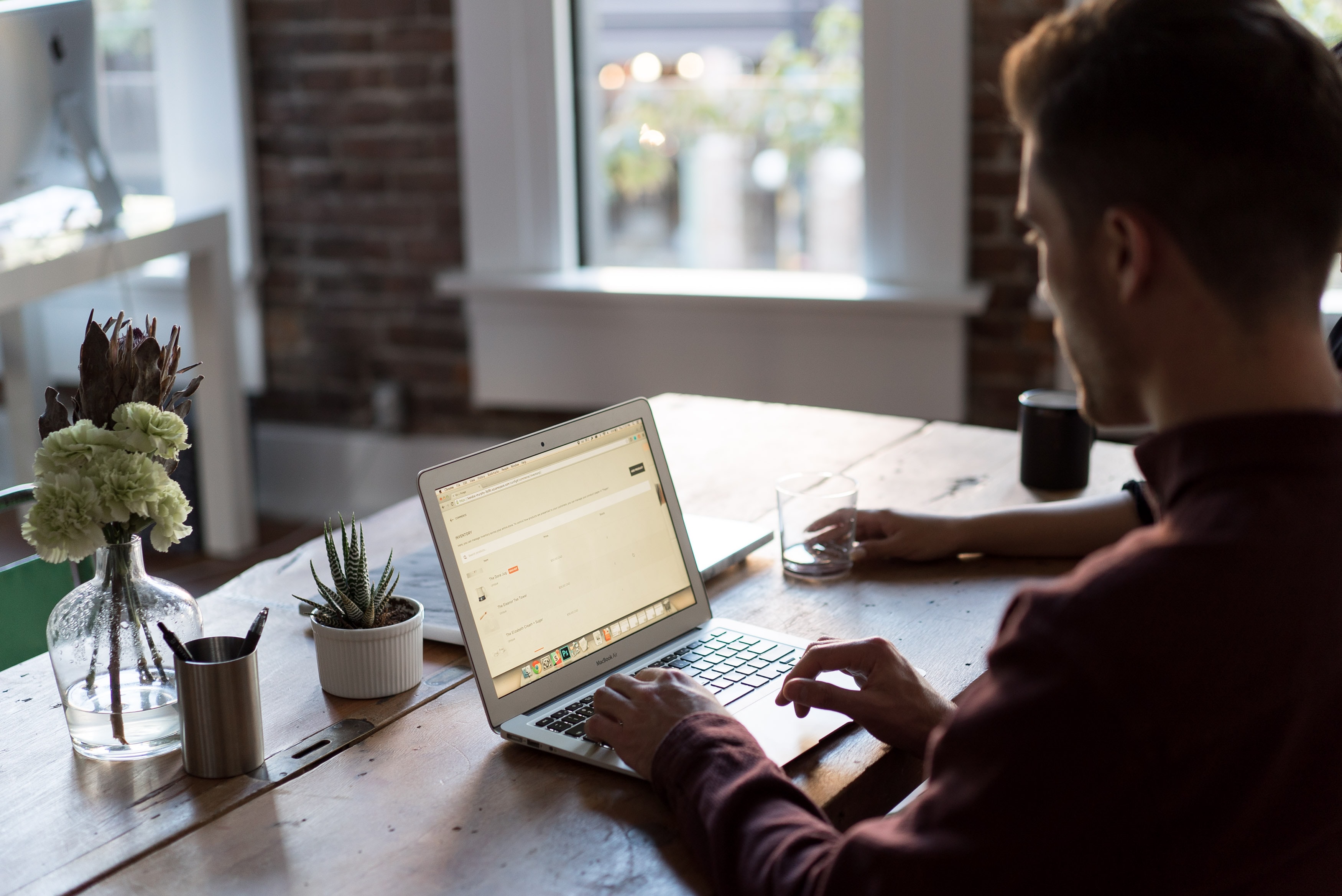 Man at desk with laptop by the window